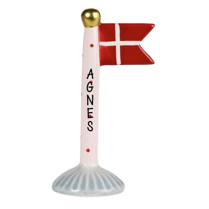 Keramisk flagstang med røde prikker, rødt flag med hvidt kors, navn "AGNES" på stangen.